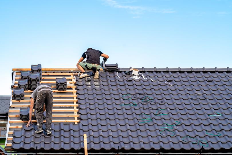 A roofer installing a new roof on a house