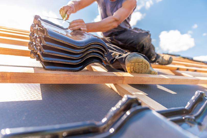 A roofer installing a new roof on a house