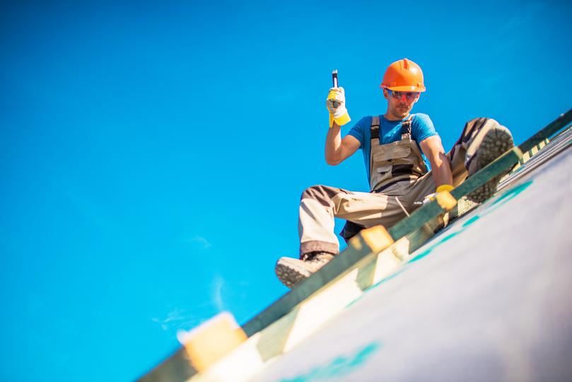 A roofer installing a new roof on a house