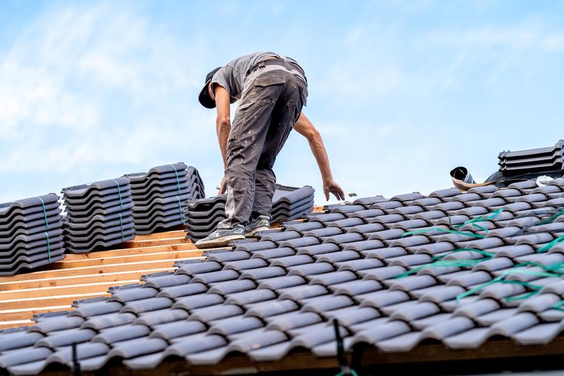 A roofer installing a new roof on a house