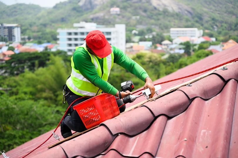 A roofer installing a new roof on a house