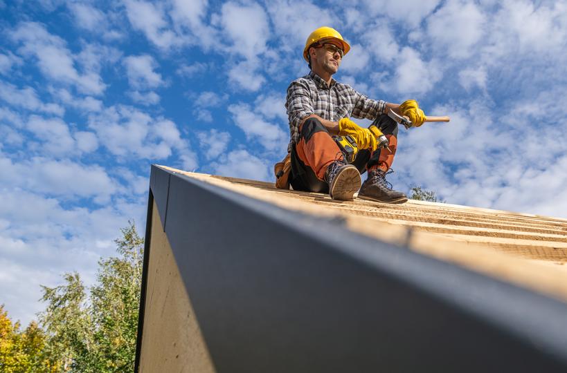 A roofer installing a new roof on a house