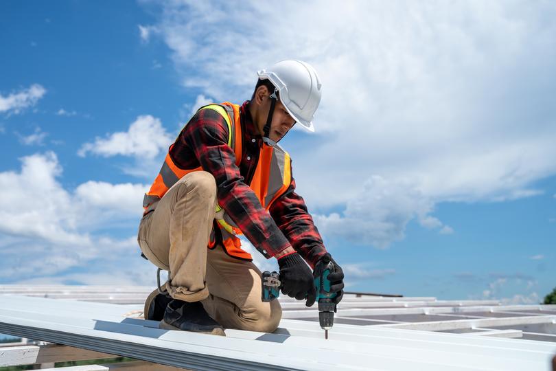 A roofer installing a new roof on a house