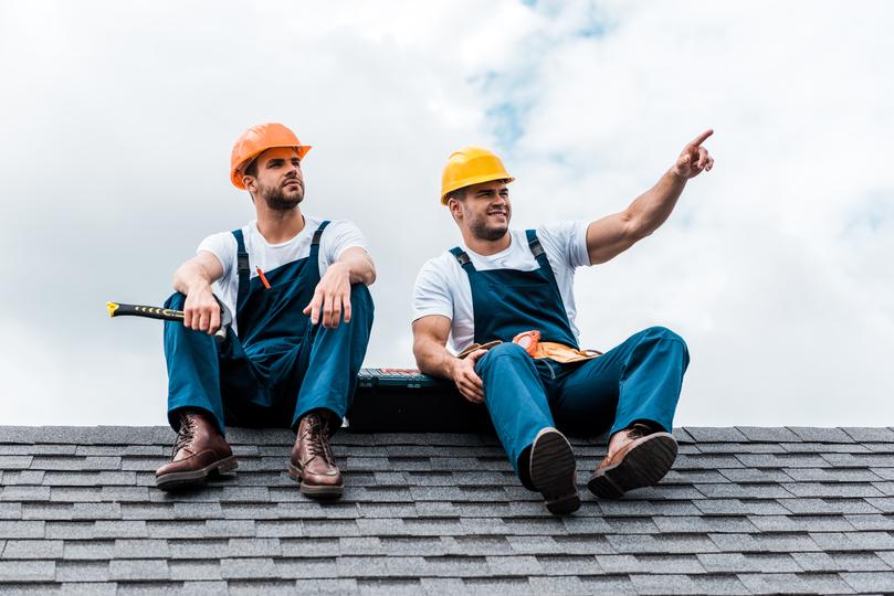 A roofer repairing a tile roof on a house in UK